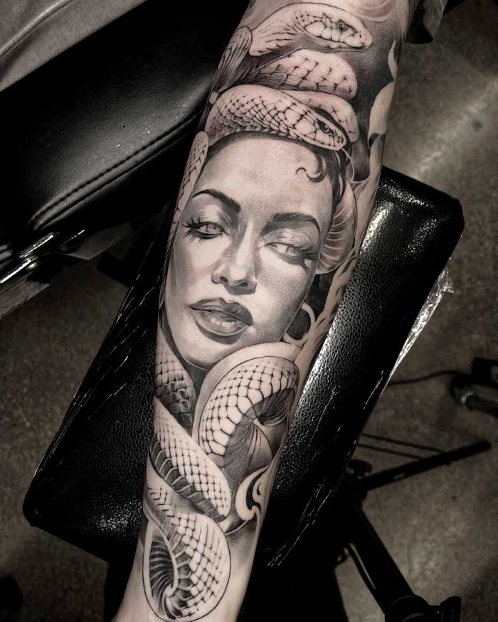 Woman and snake on lower arm tattoo by Vincent
